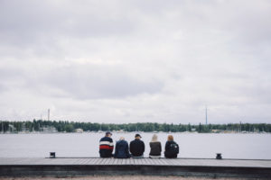 Studerande sitter på kaijen.