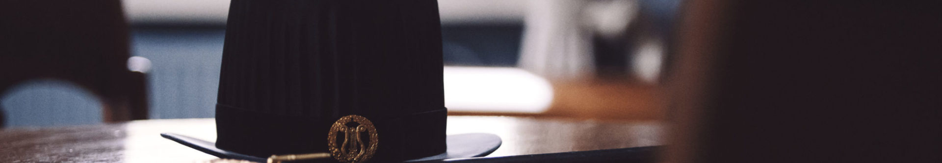 En doktorshatt och -värja på ett bord.