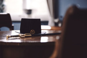 En doktorshatt och -värja på ett bord.