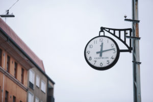 Ett utomhusur som visar kvart över tolv.