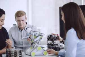 Studerande som sitter med en robot