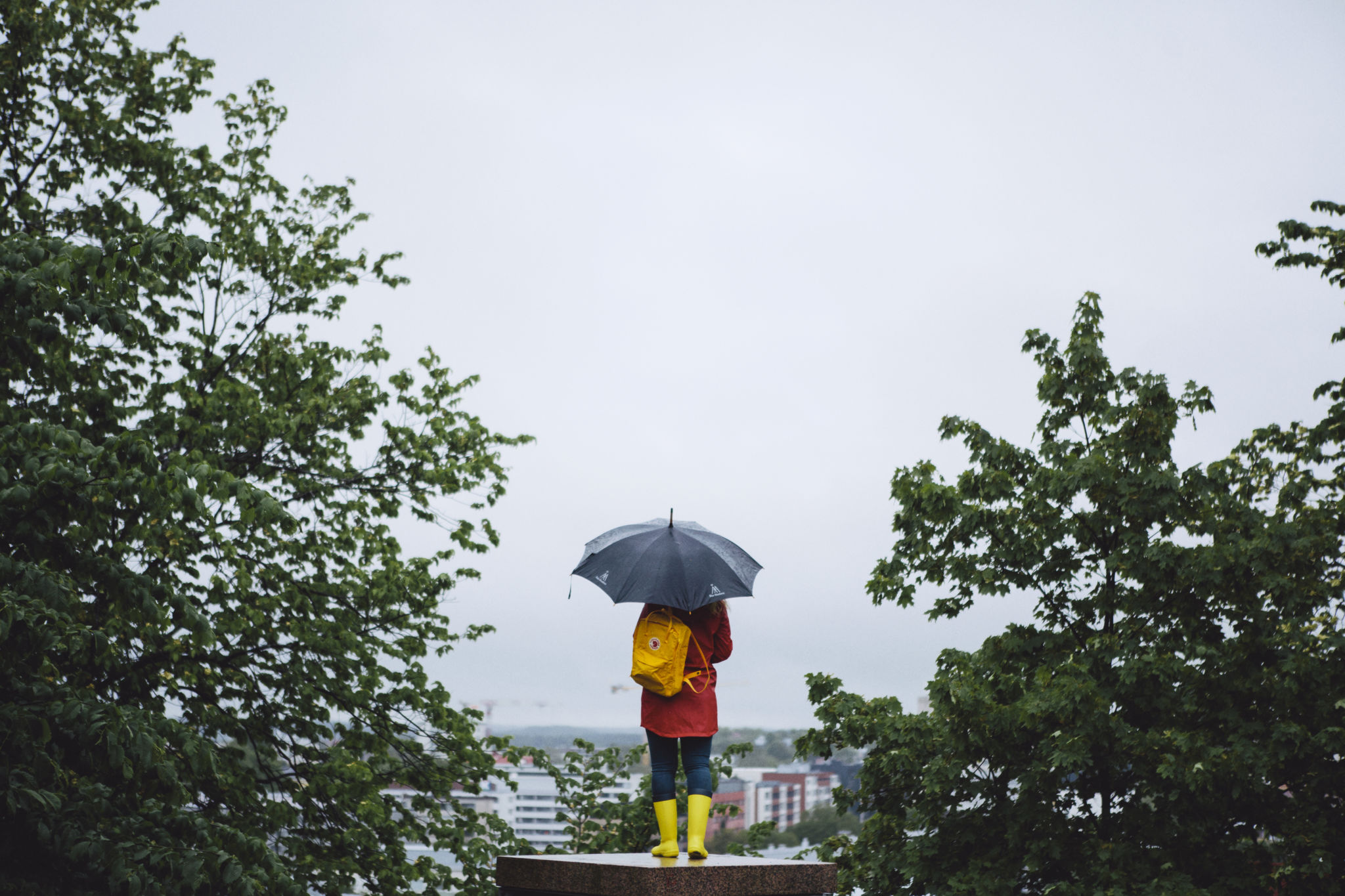 Studerande med paraply ser ut övers staden.