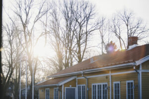 Gult hus i Åbo med solljus mellan trädtopparna.