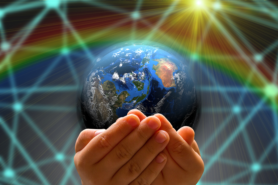 A kid's hand holding a globe in a dark background