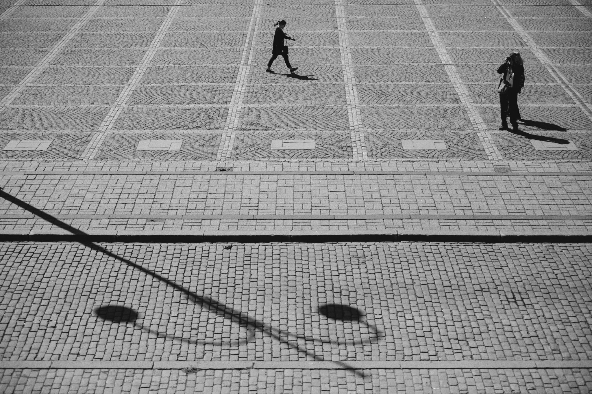 Kullerstensgata med några människor.