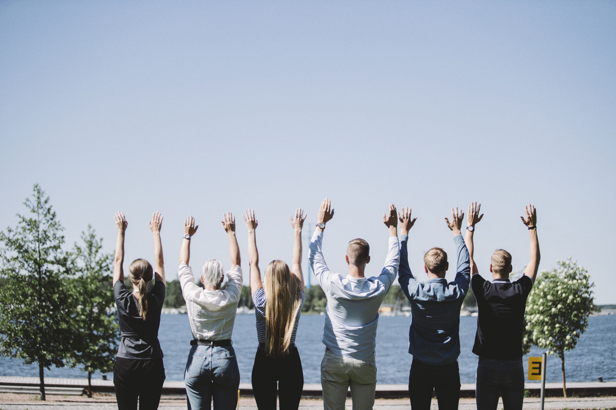 Studerande står på en rad med händerna i luften.