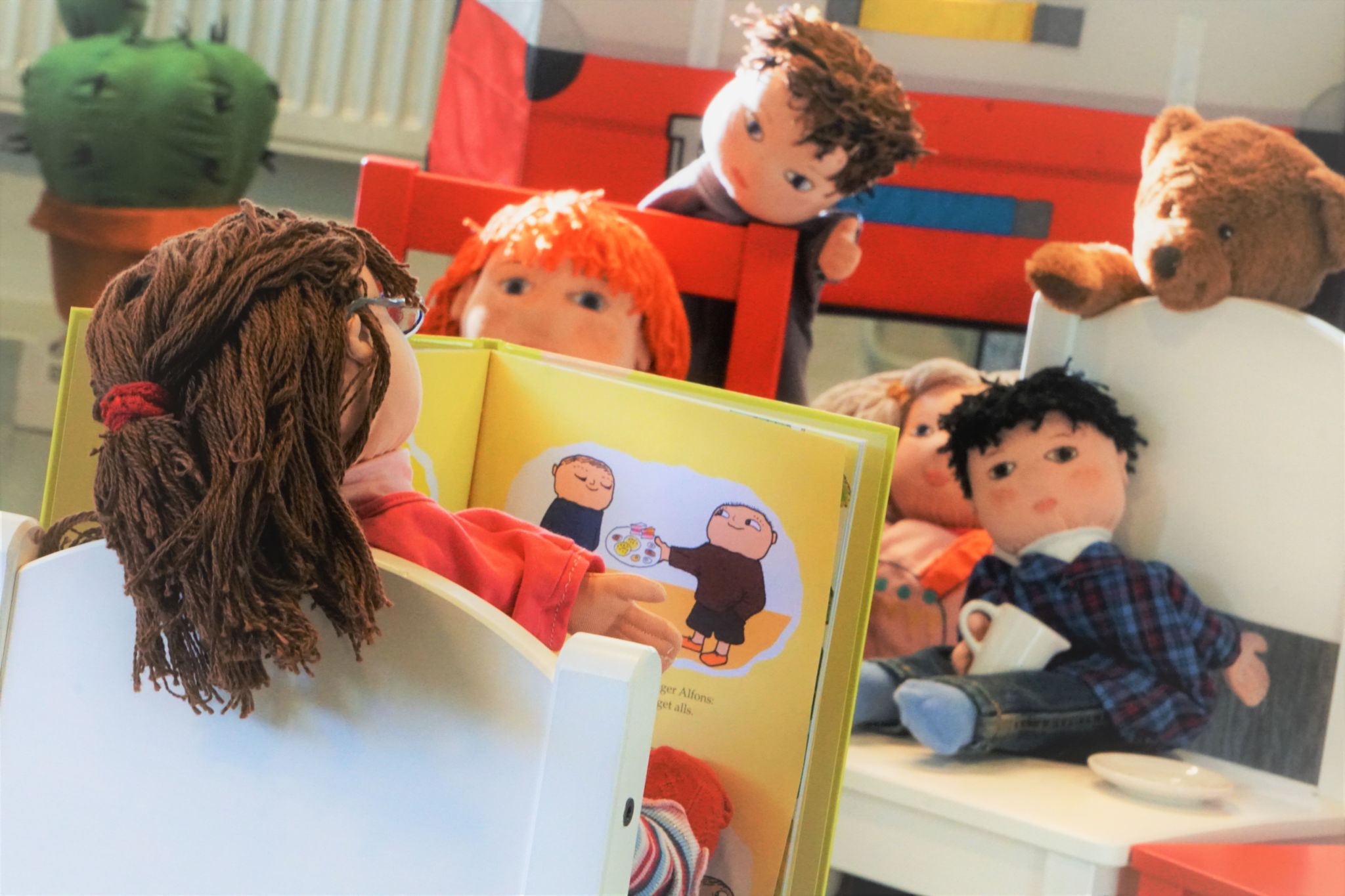 Dockor som läser en bok.