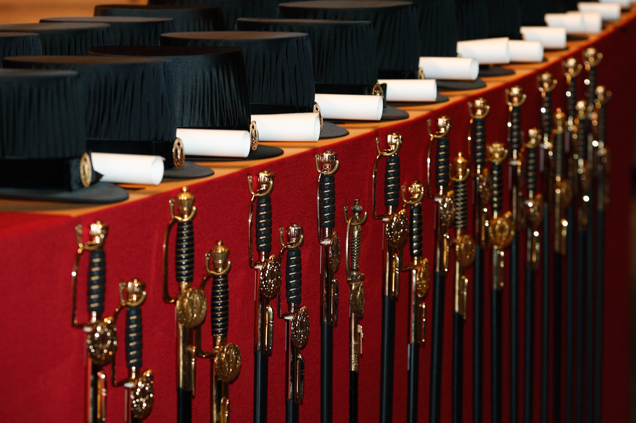 doctoral hats and swords in a row