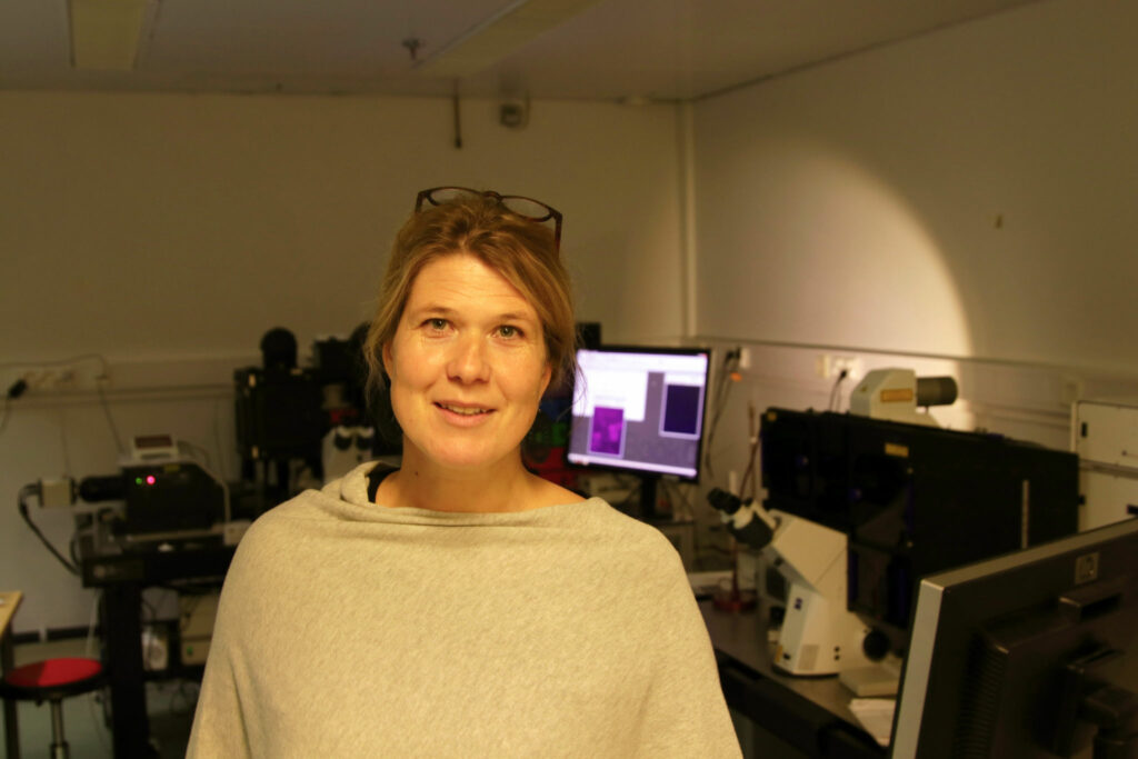 Cecilia Sahlgren i förgrunden med laboratorieutrustning i bakgrunden.