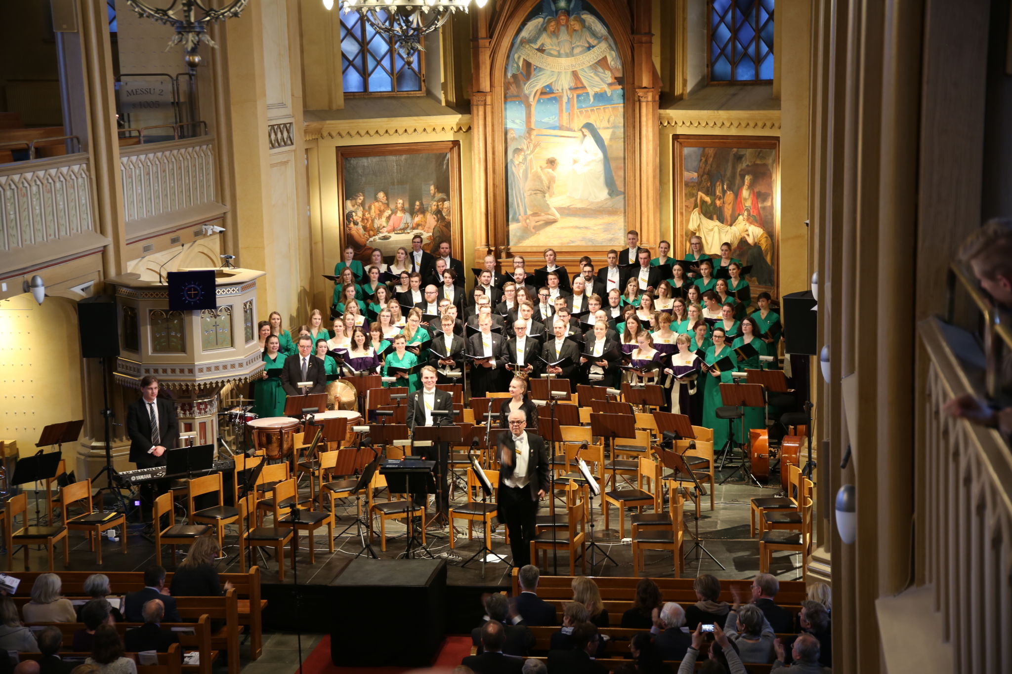 Två körer och en dirigent framför jubileumskantaten Undrans mosaik