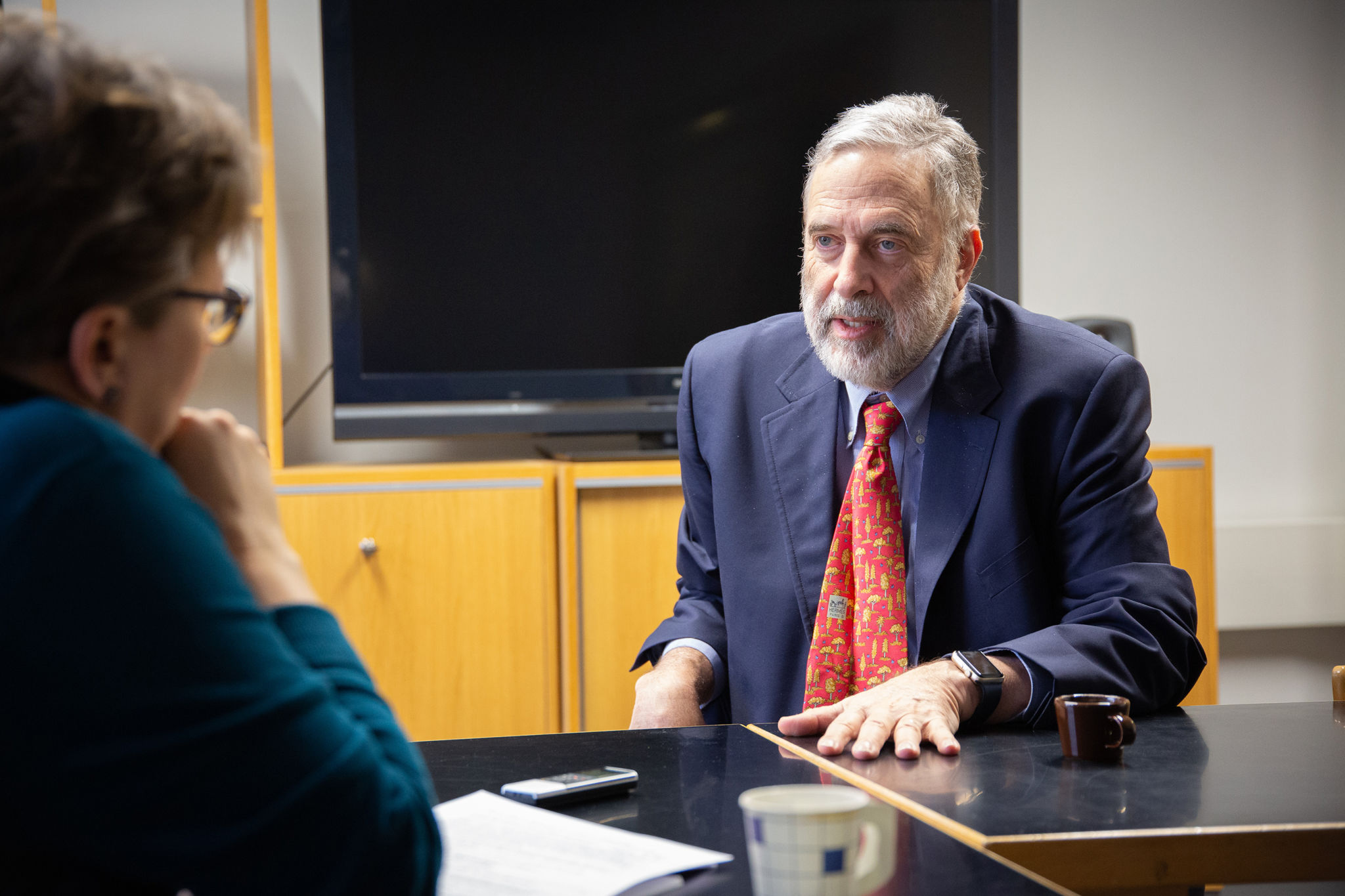 James Fishkin sittande vid ett bord, pratande med en journalist.