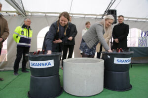 TYY:s ordförande Sini Saarinen och ÅAS:s ordförande Anna Oksanen skopar murbruk.