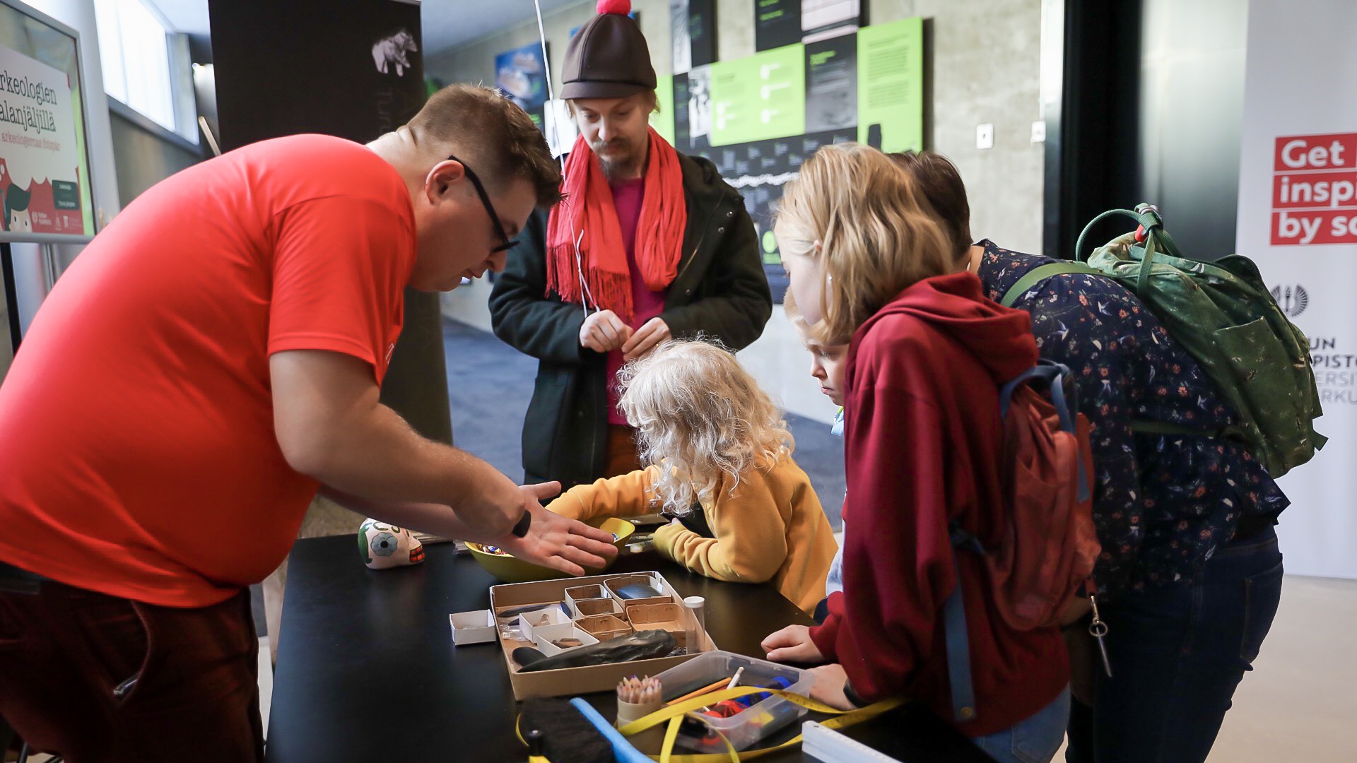 Besökare på Vetenskapsdagarna undersöker arkeologiska fynd.