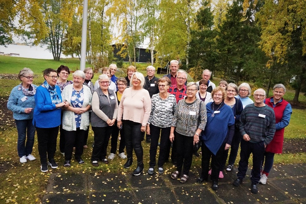 En grupp med glada människor utomhus.