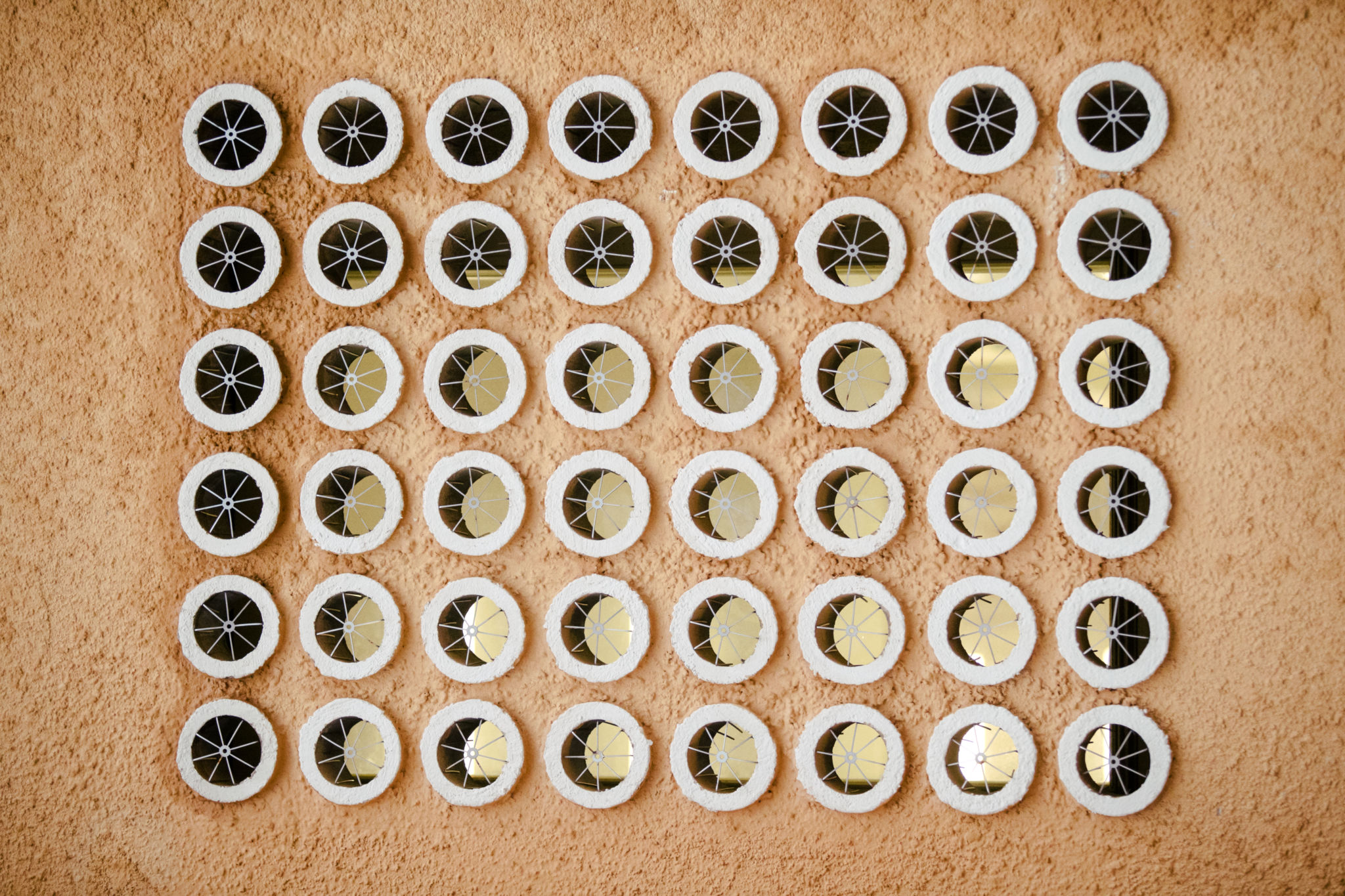 Runda ornament på en gul vägg.