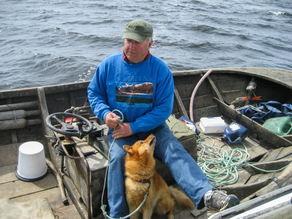 en man och en hund i en öppen båt