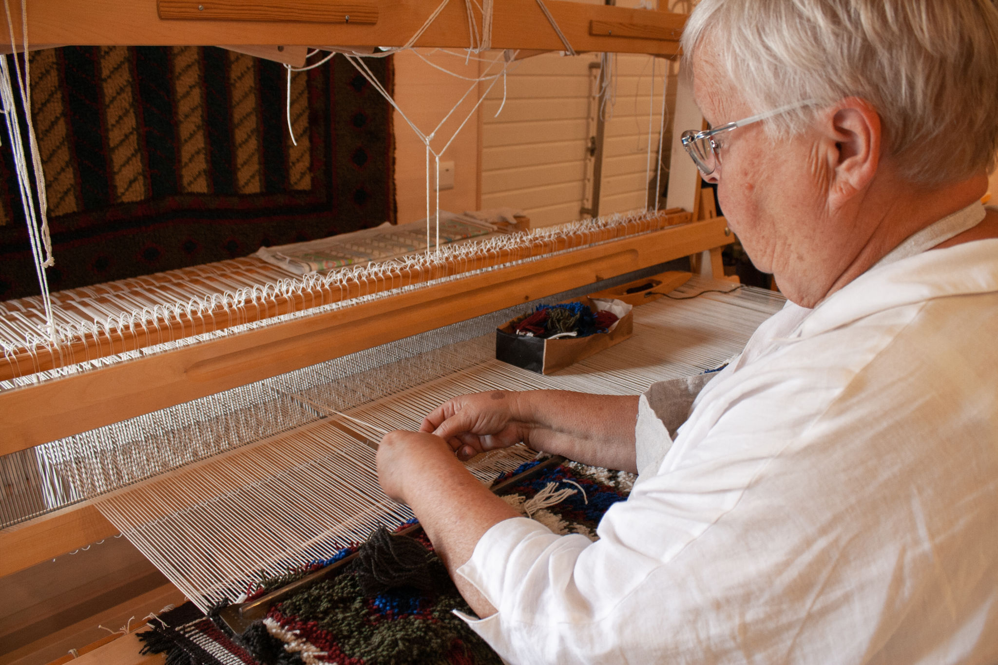 En kvinna vid en vävstol.
