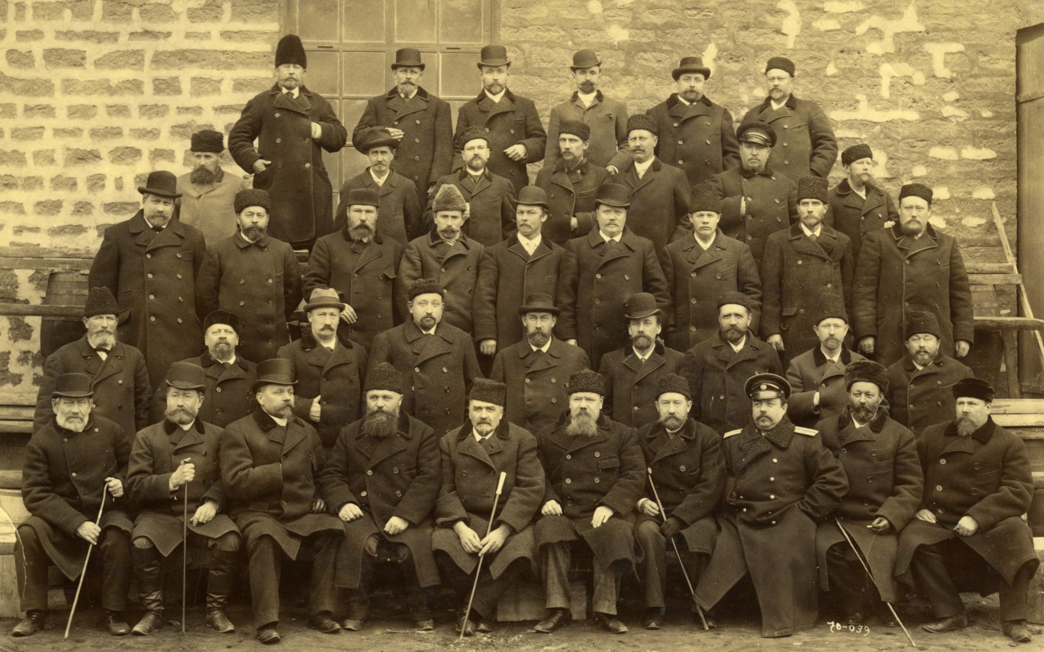 Gammal bild på män i rader.