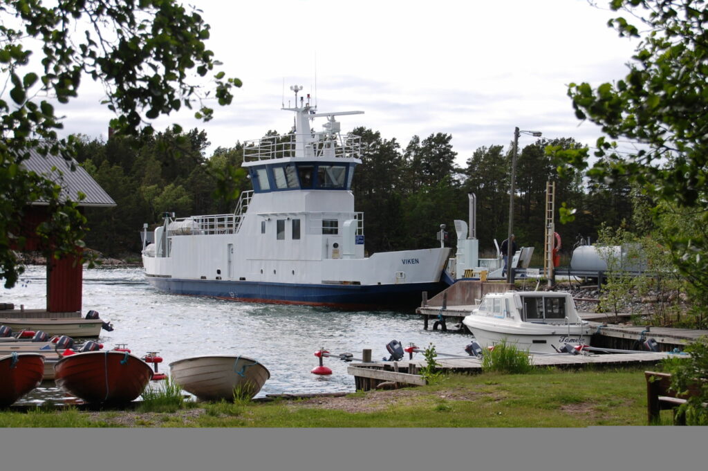 En stor förbindelsebåt ligger vid en brygga.