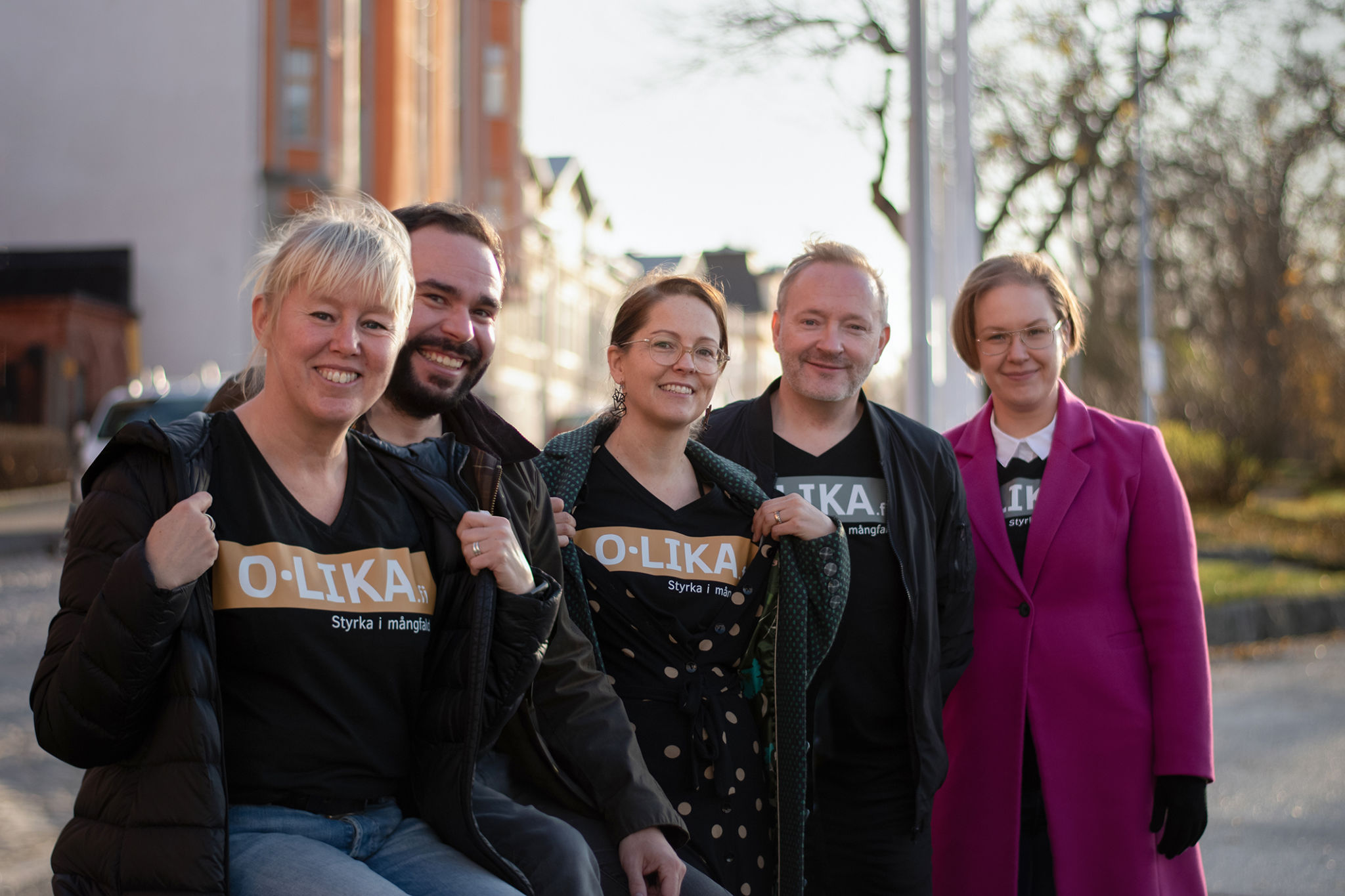 Fem glada medlemmar i projektteamet med t-skjortor där det står O.lika.
