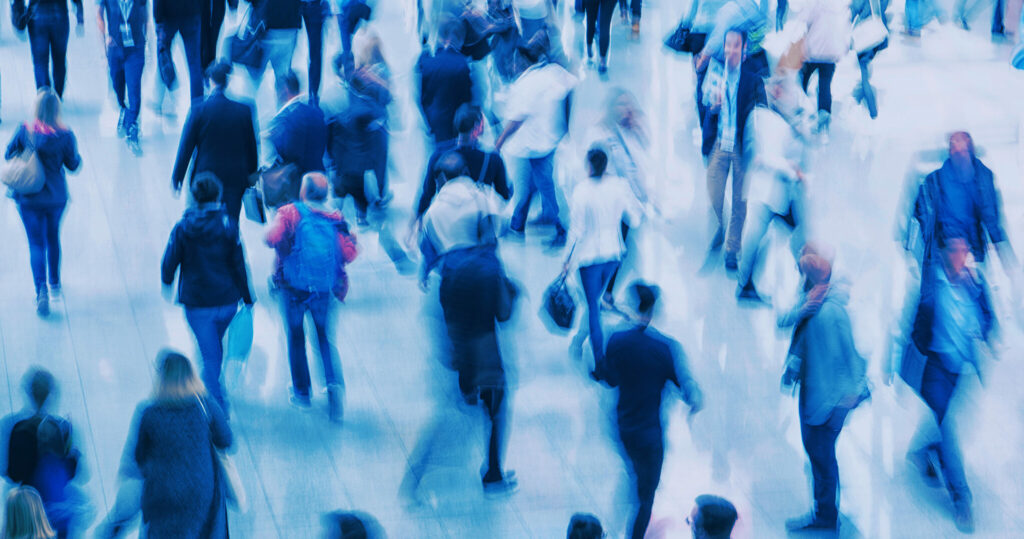 En folkmassa med många suddiga människor som rör sig.