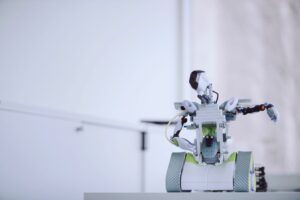 Liten vit robot med larfötter och armar.