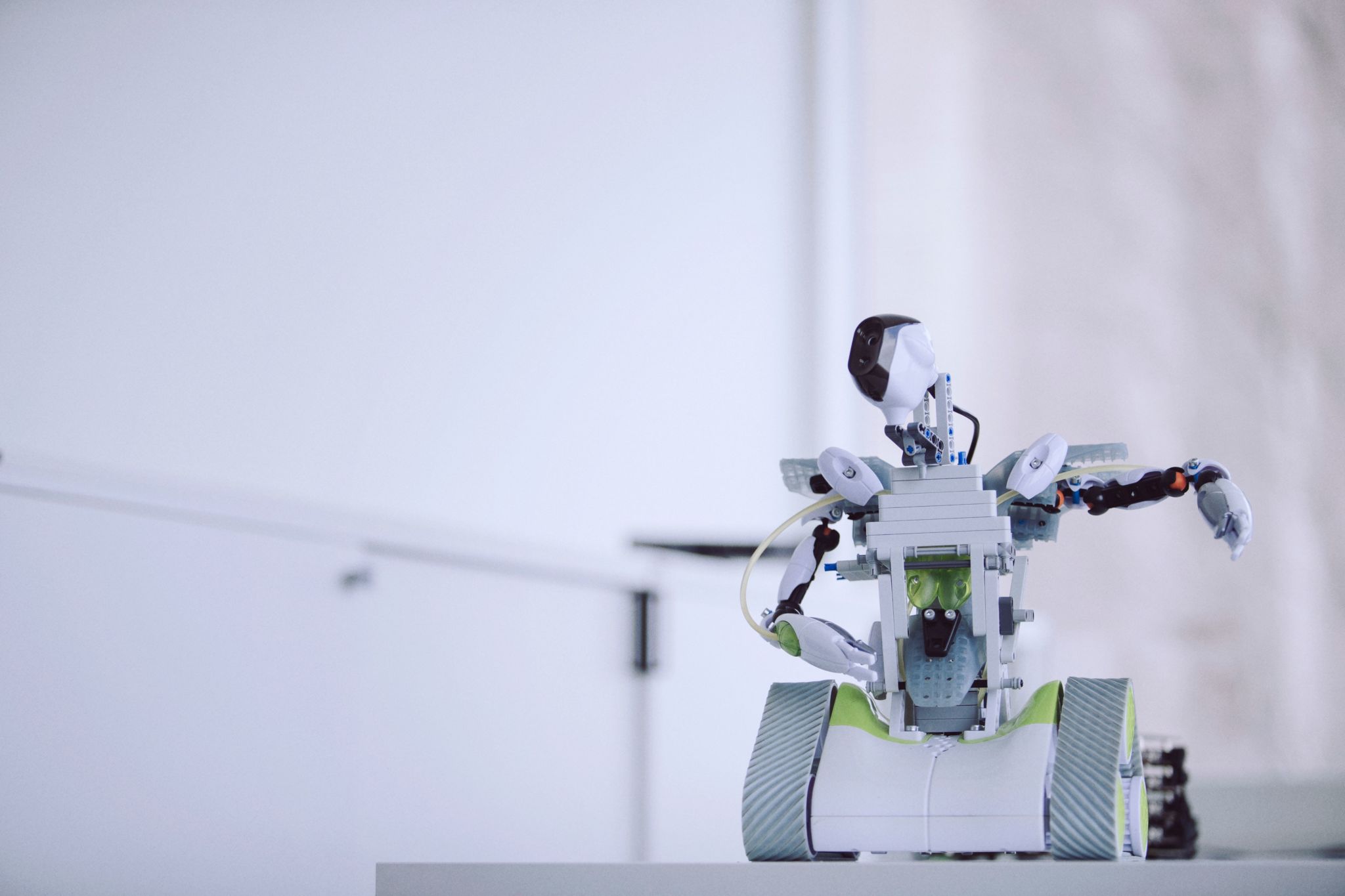 Liten vit robot med larfötter och armar.