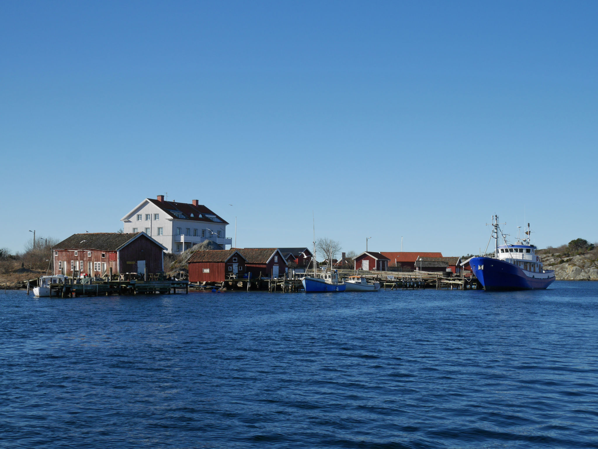 En fiskehamn fotad i vackert väder från havet.