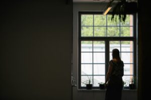 En studerande står vid ett fönster.