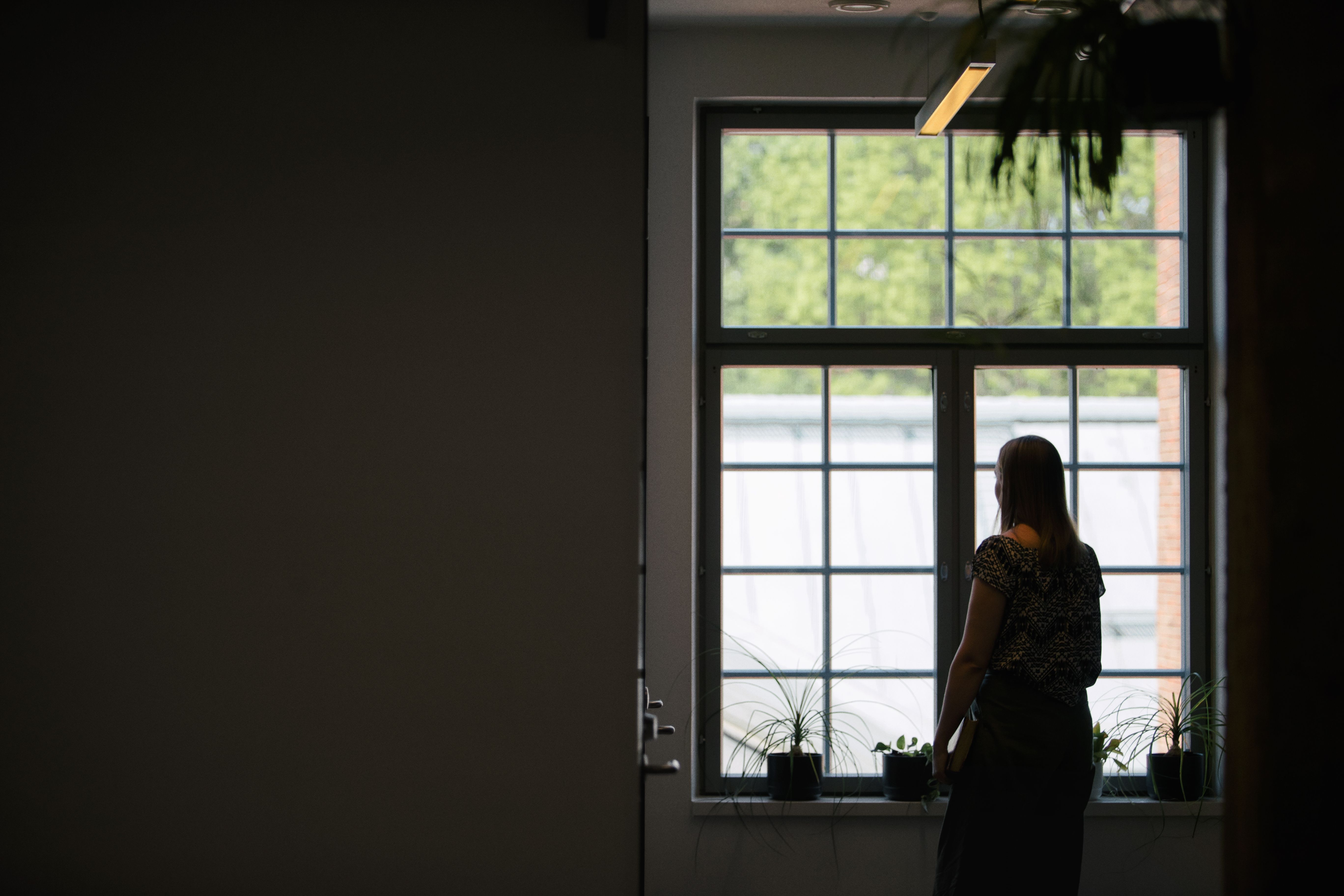 En studerande står vid ett fönster.