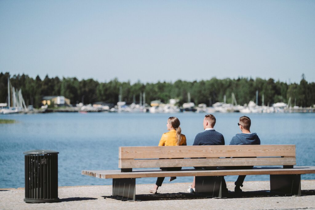 Studenter sitter på en bänk på stranden.