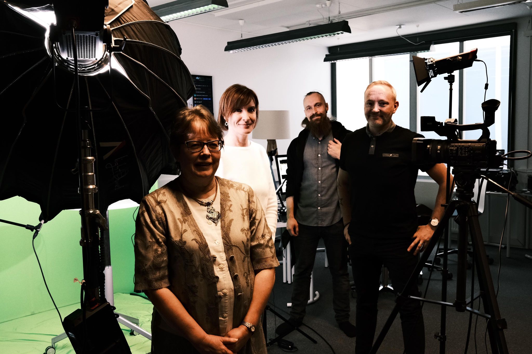 Siv Björklund, Carina Österåker, Stefan Westergård och Roland Träskelin står i en studio. I förgrunden till vänster syns en stor fotolampa och en greenscreen.