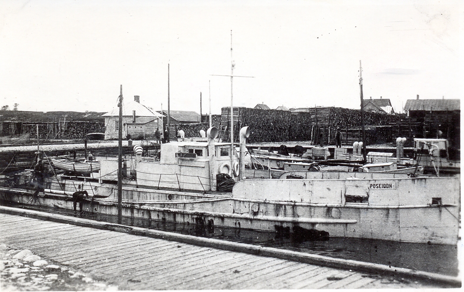 En gammla svartvit bild på ett fartyg vid kaj.