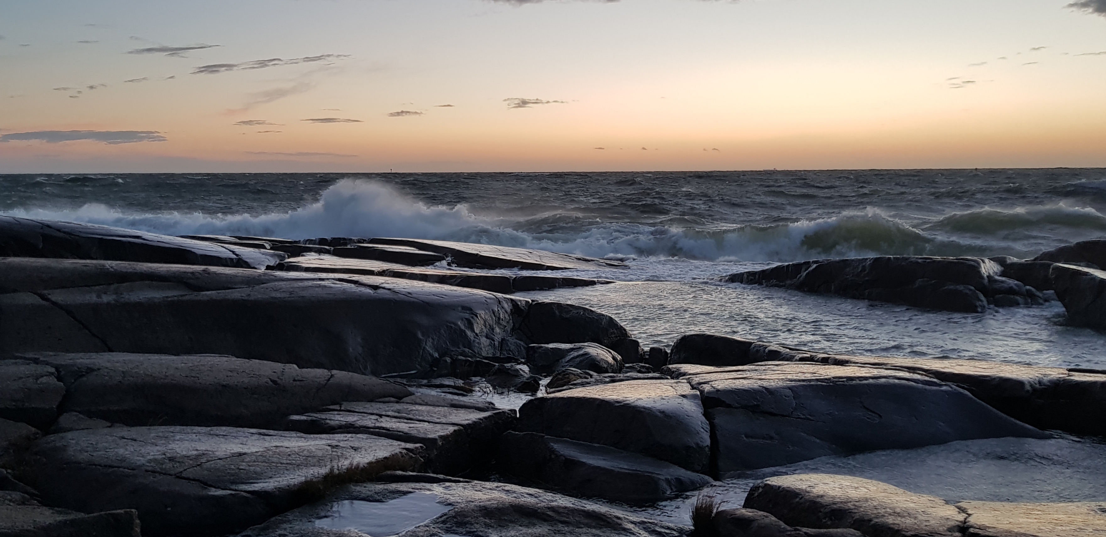 En stormig havsvy i solnedgång.