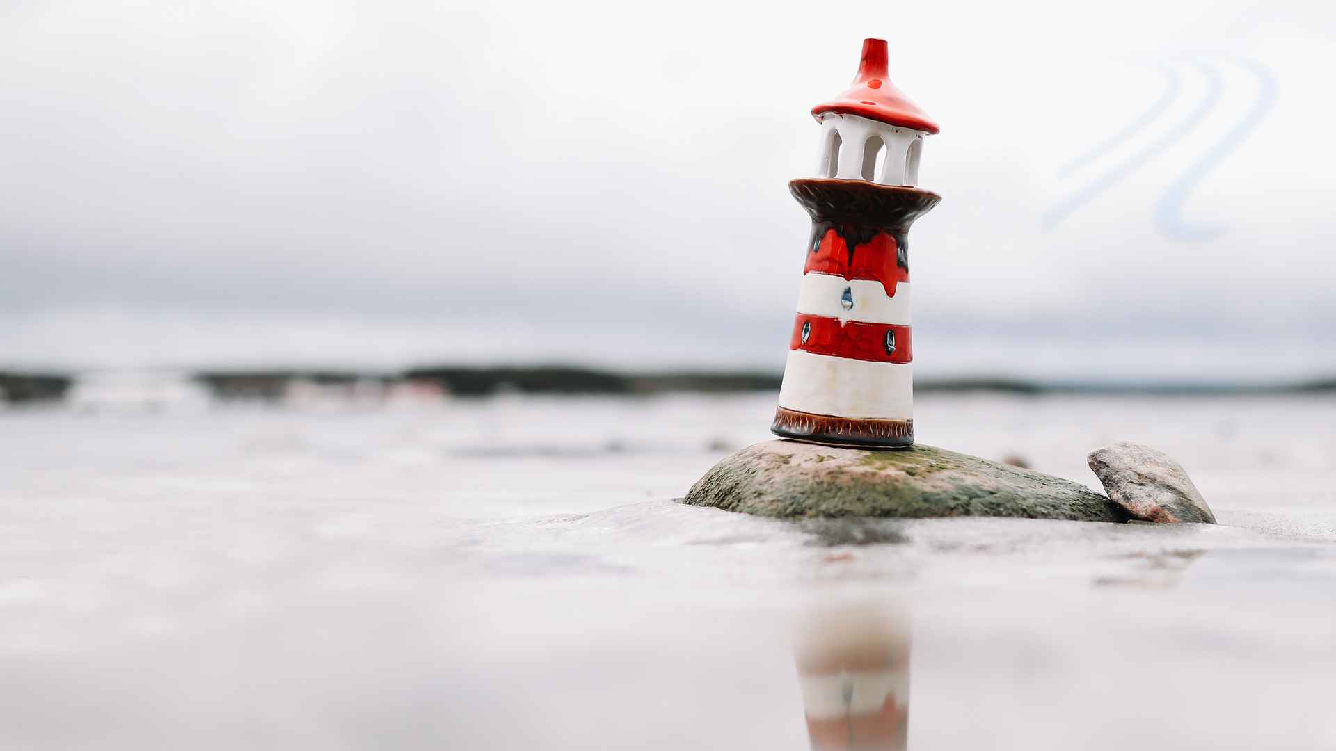 En liten fyr fotad vid vattnet.