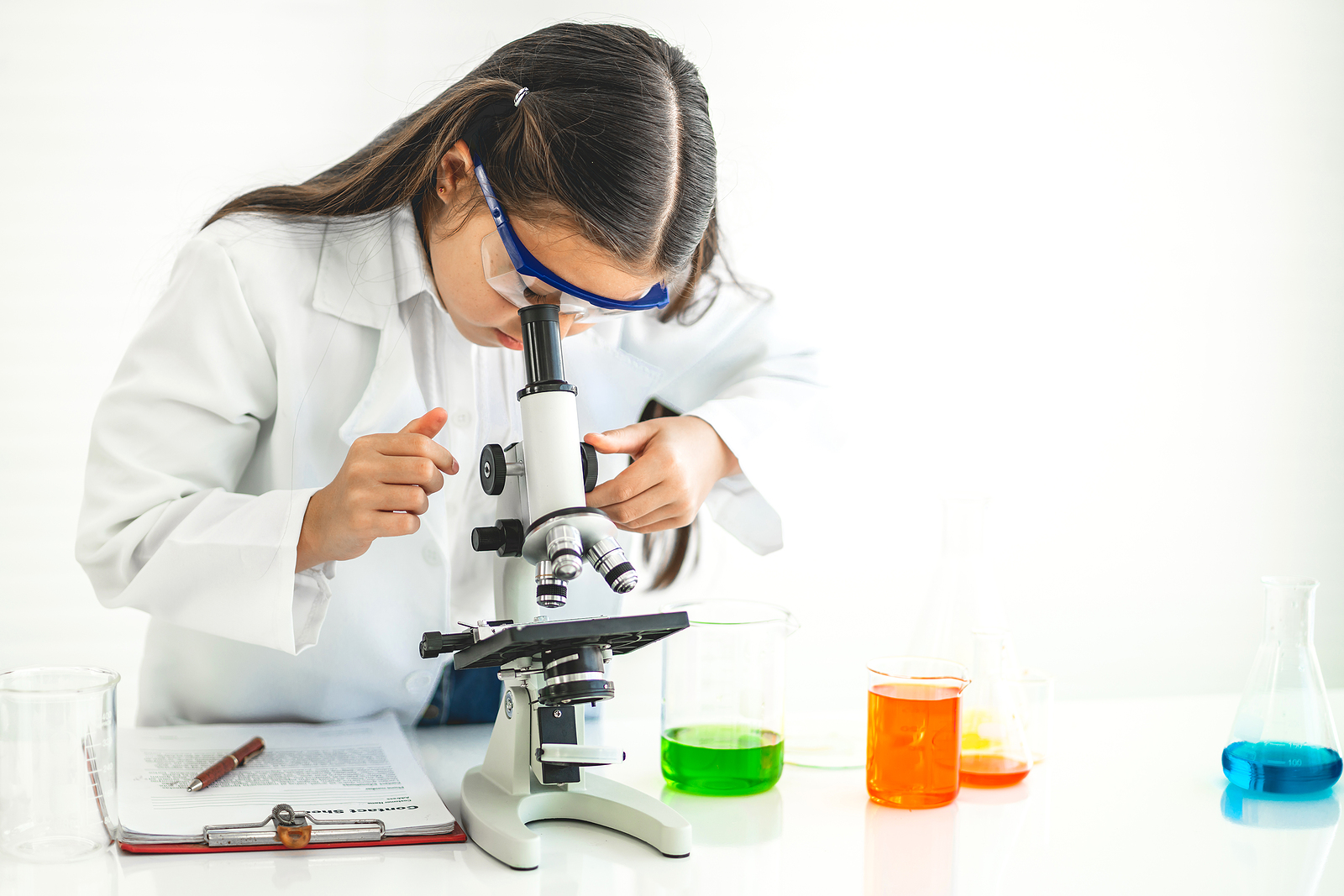 En flicka som tittar i ett mikroskop.