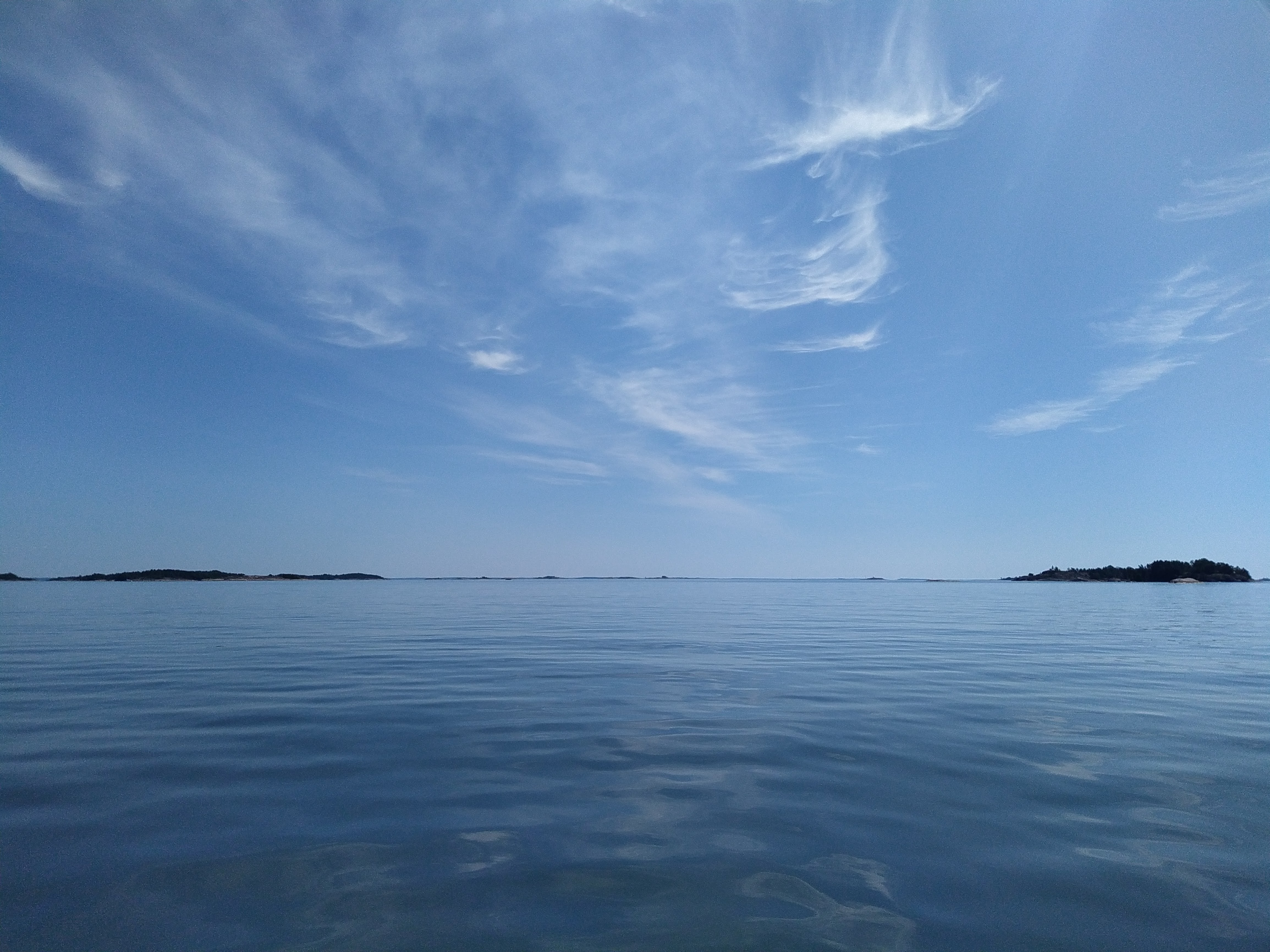 En soldisig horisont och blått hav.