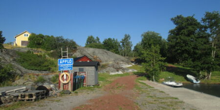 Bild tagen på Äpplö brygga, visar en skylt med namnet Äpplö, samt en livboj.