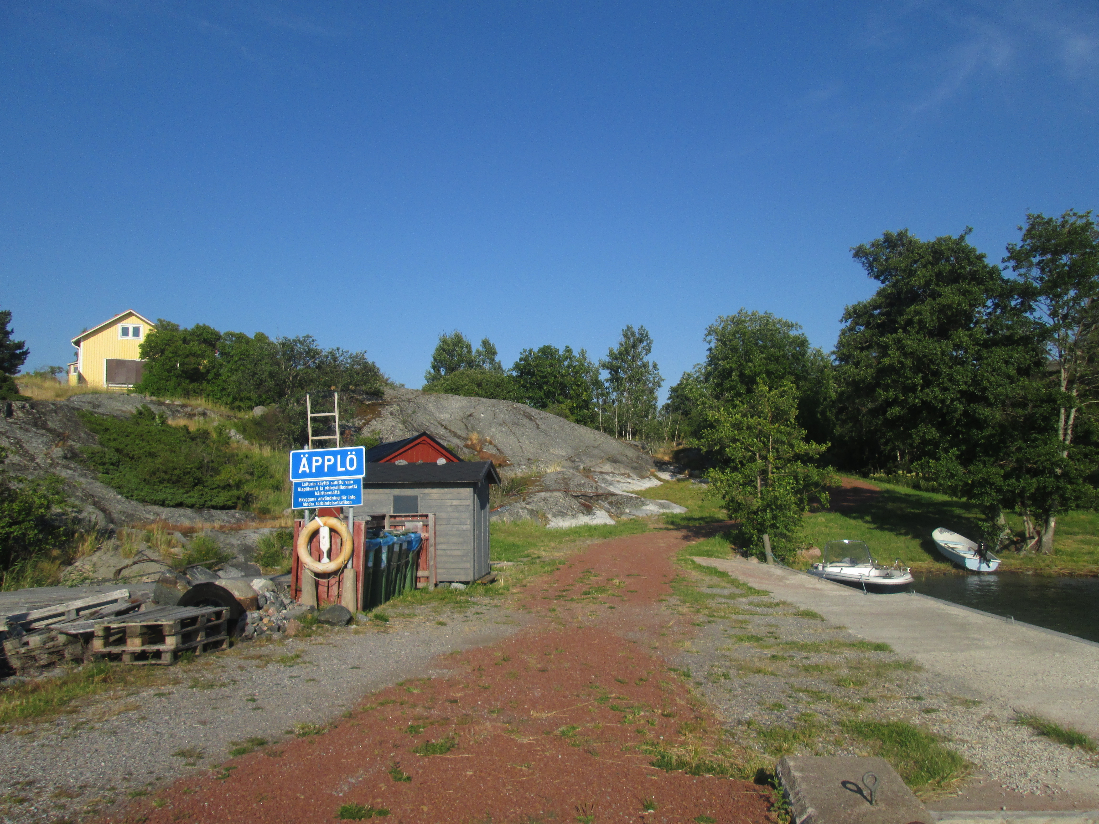 Bild tagen på Äpplö brygga, visar en skylt med namnet Äpplö, samt en livboj.