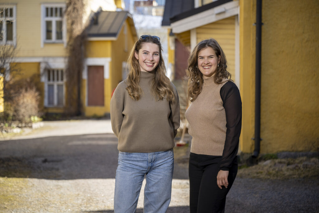 Emilia Morfin Venäläinen and Ida Lindfors standing at a courtyard in Portsa.