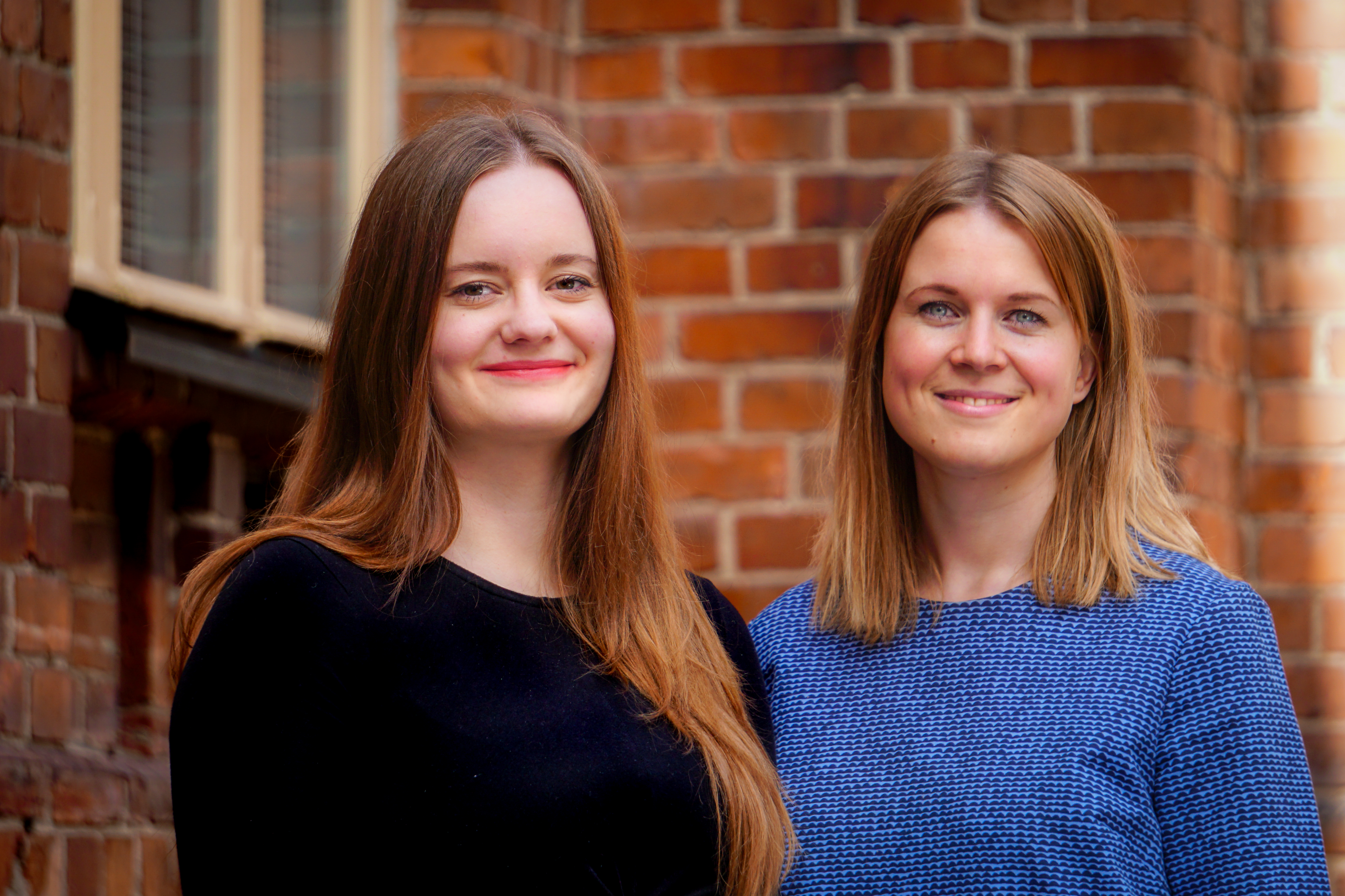 Två leende kvinnor.