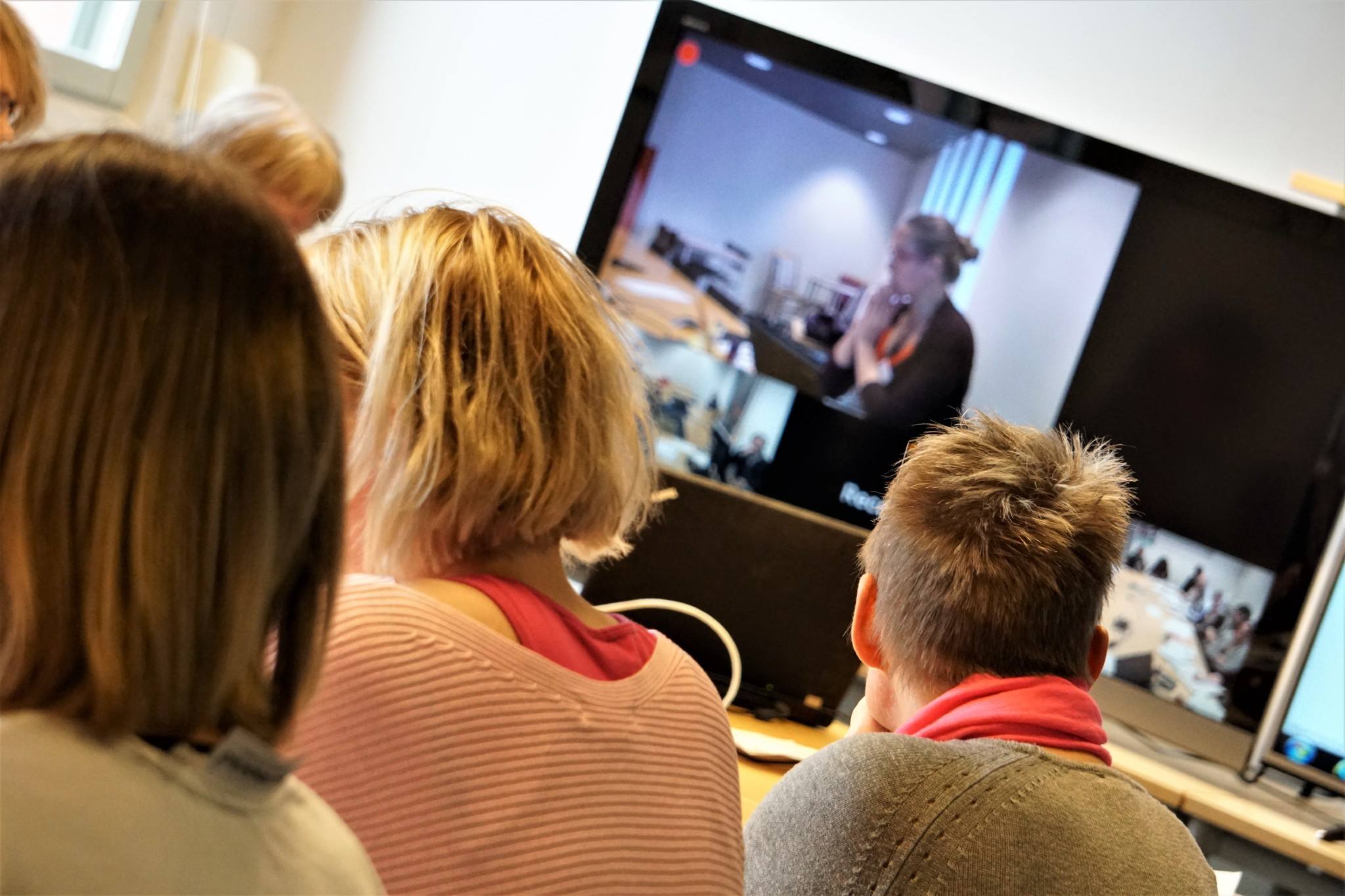 Tre kvinnor kollar på en tv-ruta i ett distansmöte