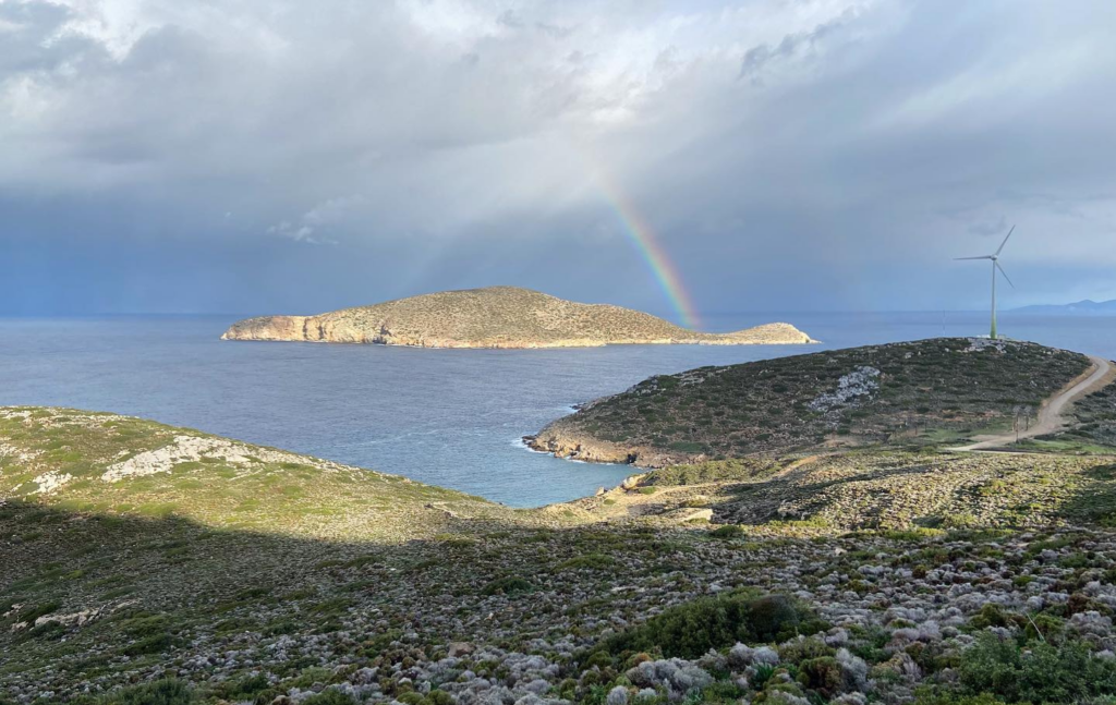 Sunny island in the sea, rainbow in the sky.