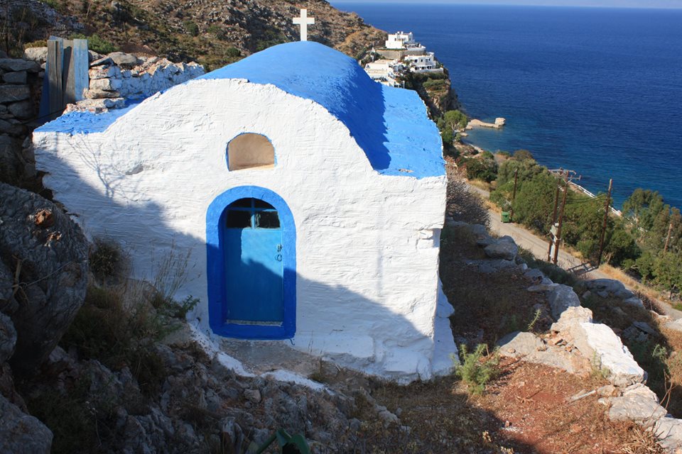 A blue-white chapel with a cross on the roof.