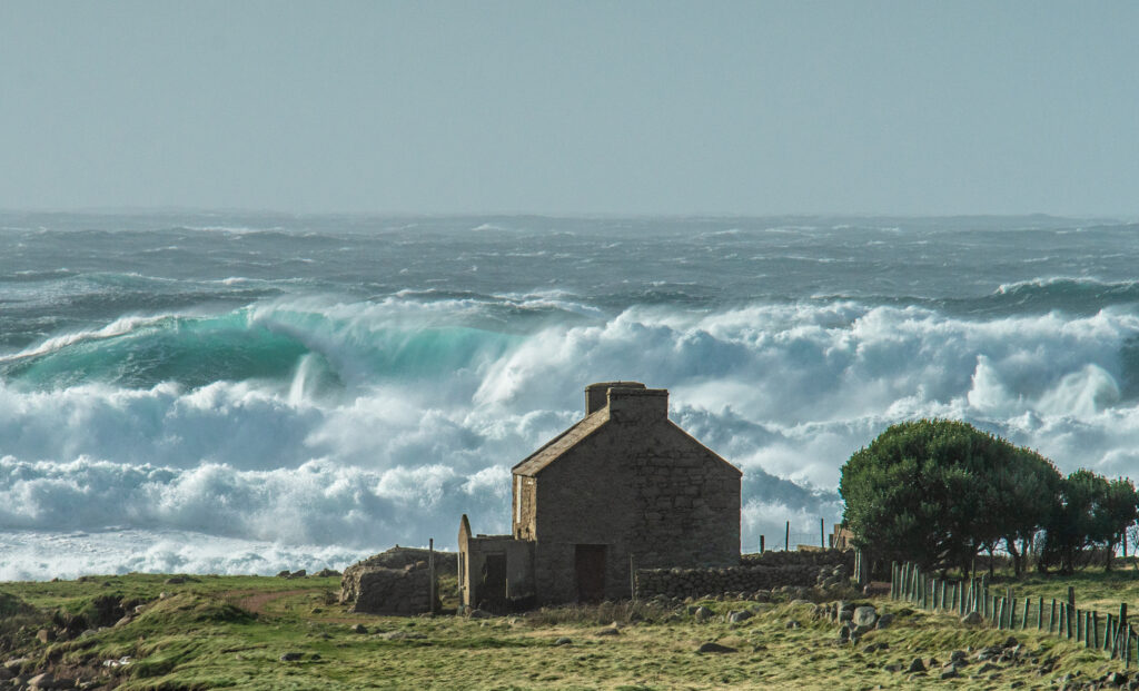 A stormy sea and a house on the shore.