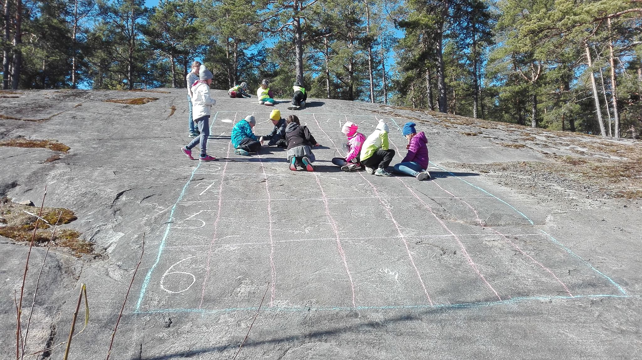 Leikkiviä lapsia kalliolla.