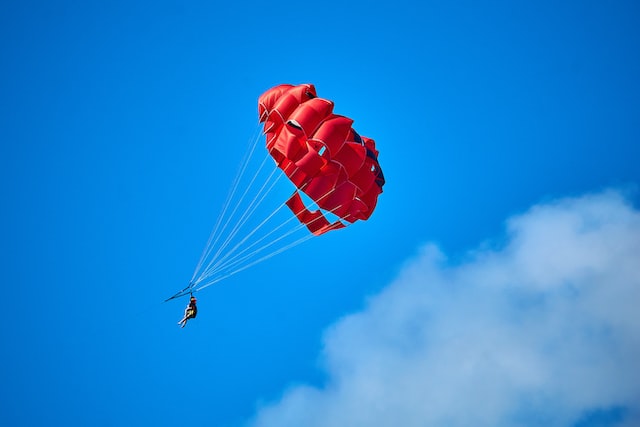 Röd fallskärm på en blå bakgrund.