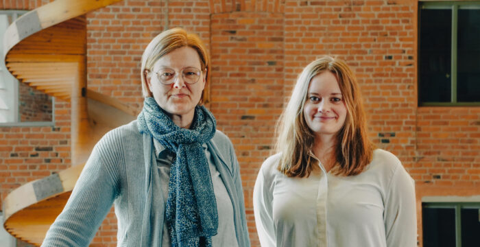 Utbildningsplanerarna Åsa Stolpe-Dahlbäck och Lisabet Sandin-Kula vid Centret för livslångt lärande vid Åbo Akademi, ståendes i Foajén i Academill.