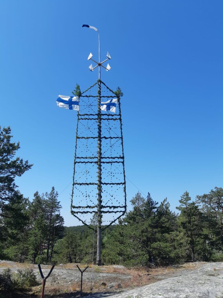 Midsomamrstång med Finlands flaggor högst upp.