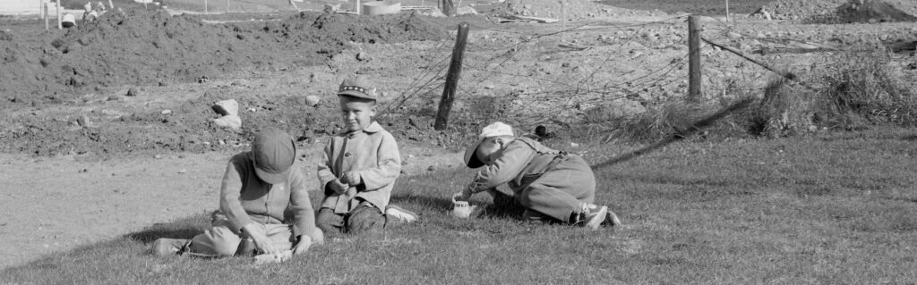 Tre barn leker på gården framför Kilometerhuset på Stationsgatan 50 i Sandviken, Vasa.